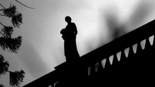 Una estatua en la parte alta de un edificio