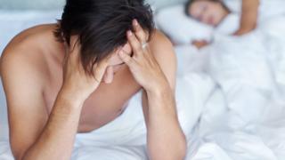 Hombre preocupado en la cama