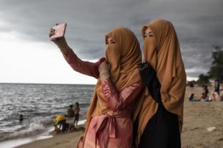 Thai women take a selfie on the Talo Kapo beach