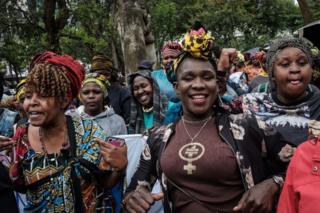 Women campaigners smile and chant as they march