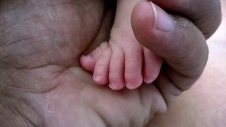 Una mano adulta acaricia el diminuto pie de un bebé (Foto: Jorge Márquez)