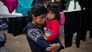 Седалина, 14-летняя девочка-мигрант из Гватемалы, держит свою четырехлетнюю сестру Нуреситу, когда они укрываются в убежище с караваном из Центральной Америки, пытающимся добраться до Соединенных Штатов, в Тихуане, Мексика, 20 ноября 2018 года || | Мигрантам предоставили убежище, но мэр Тихуаны предупредил, что город не сможет обеспечить их долгое время