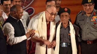 На этой фотографии, сделанной 2 апреля 2017 года, тибетский духовный лидер Далай-лама (слева) обменивается рукопожатием с отставным персоналом Ассамских винтовок Нареном Чандрой Дасом