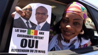 A woman in a car holds a "yes" sign on 12 March, 2016 in Guediawaye suburb in Dakar, during the campaign for referendum on revising Senegal"s constitution, including reducing the presidential mandate from seven to five years.