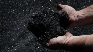 A worker in the coal industry handles coal at a coal prep plant on May 19, 2017 outside the city of Welch, West Virginia