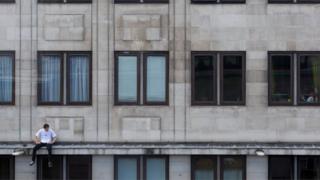 Pria duduk di pinggir apartemen di Waterloo, London, Inggris.