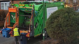 A South Tyneside Council bin collection. A worker in a high-vis jacket is loading a bin onto the back of a bin lorry.