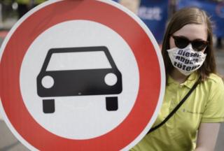 Manifestante na Alemanha usa uma máscara com os dizeres: "Emissões de combustível matam"