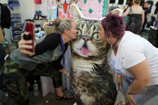 People pose for a selfie at the CatCon cat convention in Pasadena, California.