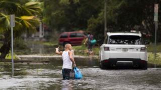 Человек пробирается по затопленной улице во Флориде