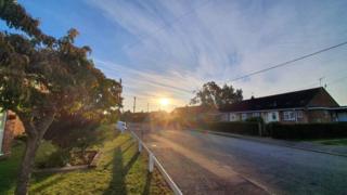 Sun rises over houses in Harleston