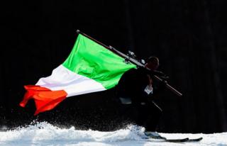 An Italian coach carries the national flag