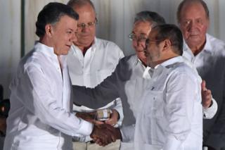 Президент Колумбии Хуан Мануэль Сантос и лидер Фарков, известный как Тимоченко, пожимают друг другу руки в Картахене в сентябре