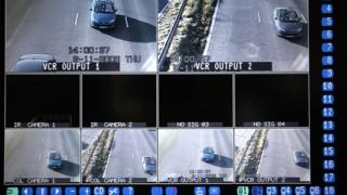 A television monitor shows the results of CCTV camera and infra-red vehicle number plate recognition cameras, tracking vehicles travelling on the M62 motorway in Cheshire