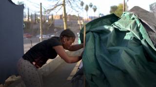 Mulher entrando em barraca em Skid Row, em Los Angeles