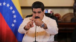 Президент Венесуэлы Николас Мадуро показывает на камеру скрещенными указательными пальцами во время встречи с министрами в Каракасе