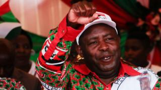 In this file photo taken on May 16, 2020 Evariste Ndayishimiye, Burundi"s Presidential candidate of the ruling party the National Council for the Defense of Democracy - Forces for the Defense of Democracy (CNDD-FDD), reacts to supporters during the last day of their campaign in Bujumbura, ahead of the Presidential and General election scheduled for May 20, 2020 despite the COVID-19 coronavirus pandemic. -