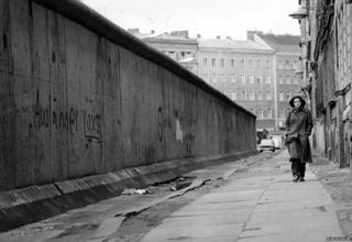 Woman walking alongside Berlin Wall, circa 1962-1968