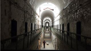 Russell Craig walks a cell block after hours