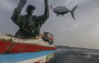 Senegalese fisherman Modu Samba catches a fish in the Atlantic Ocean off the 400 year old fishing village of Ngor, near Dakar, 26 February 2019.