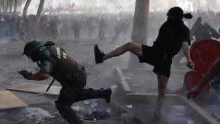 Demonstrators clash with police during a protest in the central Plaza Italia in Santiago, Chile, 12 November 2019.