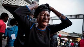 One woman wey wear black as she dey cry for her family wey die. January 2017