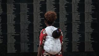 Woman looking at list of Rwanda genocide victims