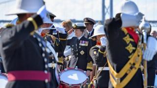 Princess Anne listens to the Band of HM Royal Marines at Hawes Peir