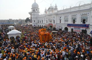 Sikh pilgrims take part in a religious ritual as they gather to celebrate the 550th birth anniversary of Guru Nanak Dev, at Nankana Sahib