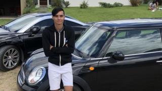 Santiago Lopez standing next to two cars in Buenos Aires province, Argentina