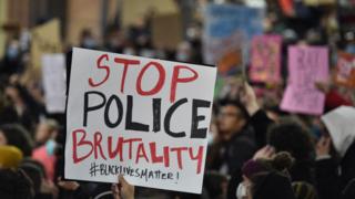 A protester at Sydney's Black Lives Matter rally holds up a 'Stop Police Brutality' sign