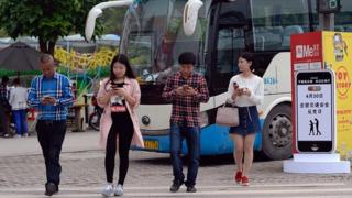 Des volontaires participent à une campagne contre le "phubbing" dans la zone touristique de Fuling, en Chine.