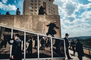 A group of Jewish people gather next to a building