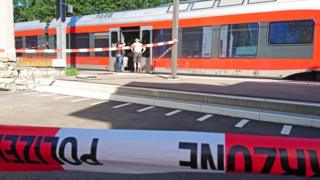 Policemen stand by a train at the station in Salez.