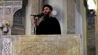 Человек, который якобы был лидером воинствующего Исламского государства Абу Бакр аль-Багдади, совершившего то, что было бы его первым публичным выступлением, в мечети в центре второго города Ирака, Мосула, согласно видеозаписи, размещенной в Интернете 5 июля 2014 года, в этом неподвижном изображении, взятом из видео.