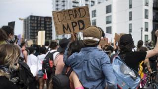 Protesters hold a placard that reads "Defund MPD (Minneapolis Police Department)" at a rally in Minneapolis, Minnesota. Photo: 6 June 2020
