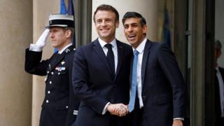 French President Emmanuel Macron (C) greets British Prime Minister Rishi Sunak upon his arrival at the Elysee Palace in Paris