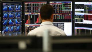 Trader watches multiple screens