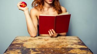 Mujer sin camisa leyendo un libro