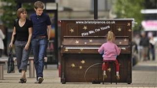 A girl plays a piano installed in Bristol's Broadmead in 2009