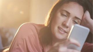 فتاة تتصفح هاتفها النقّال