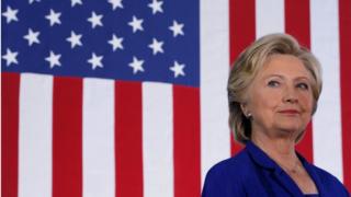 Hillary Clinton o flaen baner yr UDA
