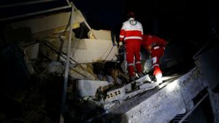 Socorristas buscan sobrevivientes en un edificio colapsado en Sarpol-e Zahab, Irán.