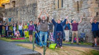 Y dorf yn cynhesu ar gyfer y gig yn y castell