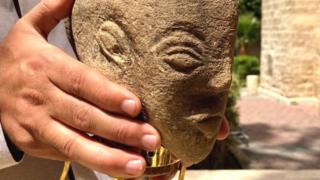 Un hombre sostiene la cabeza de piedra caliza de una escultura de 4.500 años de antigüedad que se dice que representa a la diosa cananea Anat, que fue encontrada por un agricultor en la Franja de Gaza.
