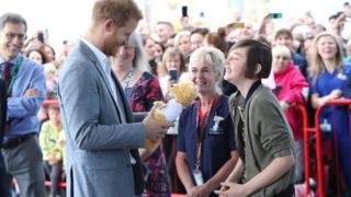 Prince Harry, Duke of Sussex receives a gift from former patient Daisy Wingrove, aged 13