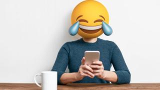 Persona con cabeza de emoji sonriente.