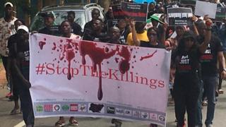 Protesters carry placard