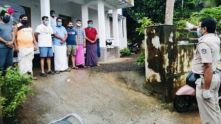 A police officer salutes civilian rescuers in Calicut