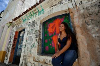 Fernanda Silmara Silva dos Santos sentada em frente a uma casa em Natal